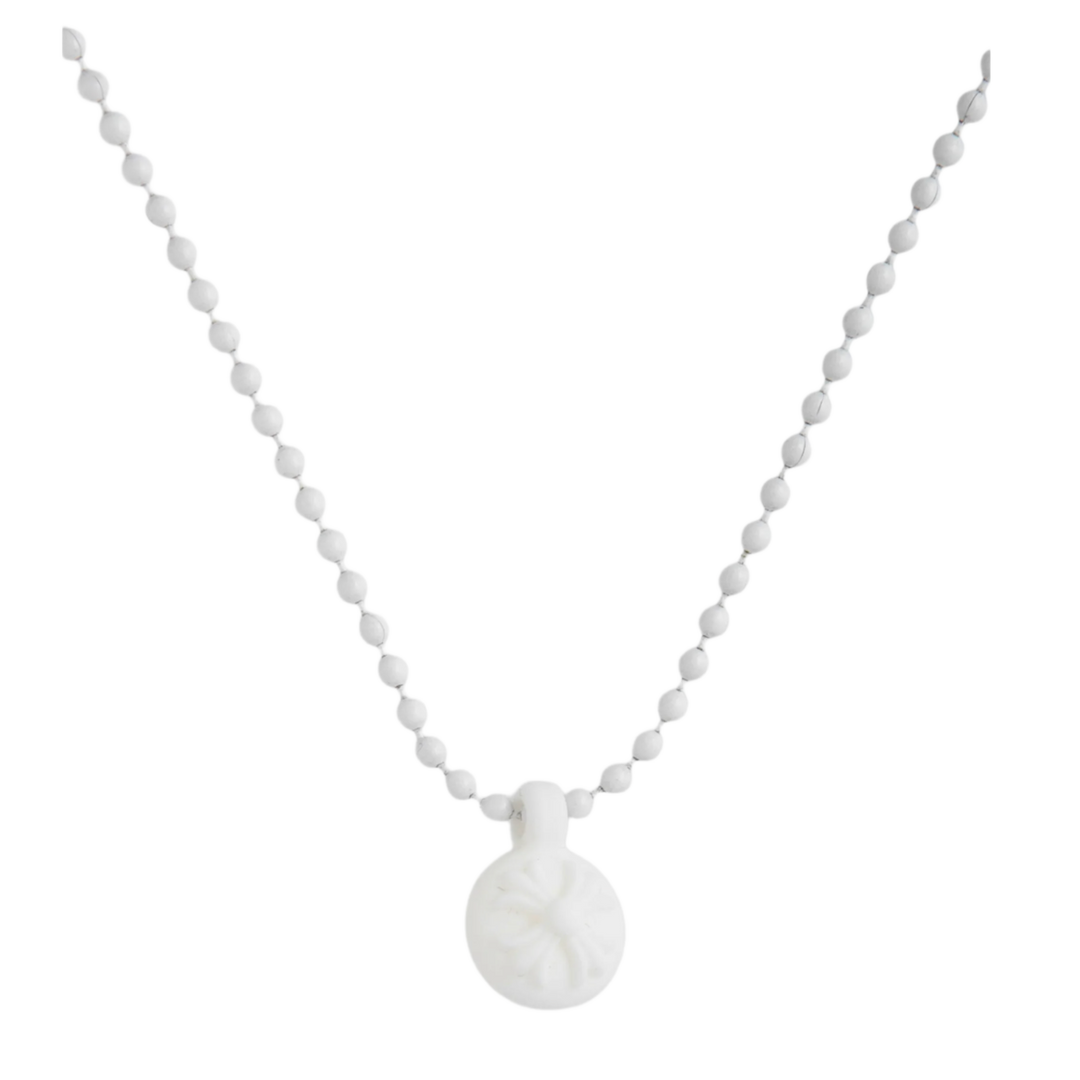 A front view of the Chrome Hearts 'Silichrome' necklace draped in a deep V-shape, highlighting the unique matte white silicone molded crossball bead chain and matching circular cross charm pendant.