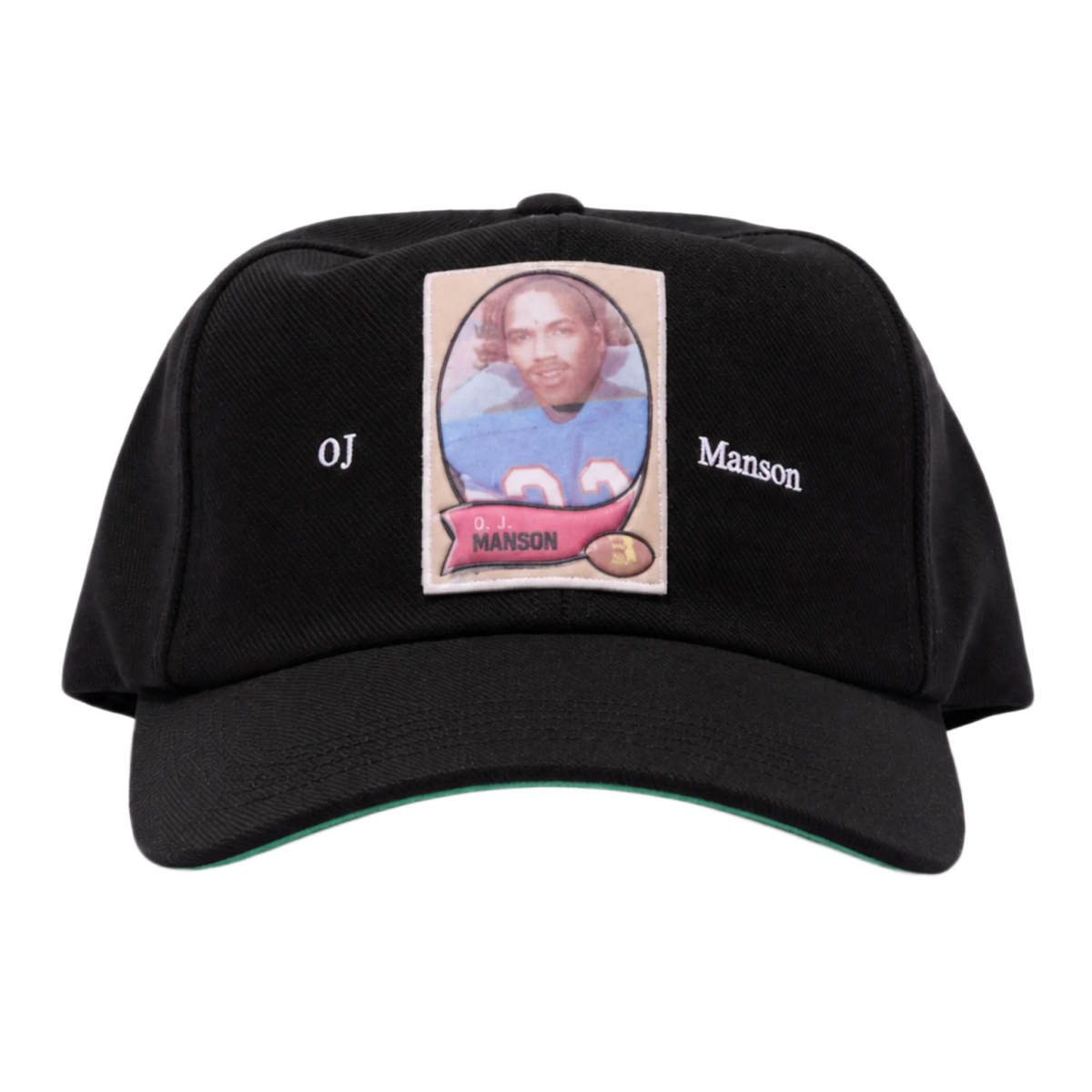 A straight front studio layout view of the Paly 'OJ Manson' hat, showcasing an unstructured six-panel vintage dad hat profile crafted from a premium washed jet-black cotton twill canvas, featuring a curved stitched brim, a centralized rectangular photo-graphic panel patch screen-printed on the front crown depicting an athletic sports trading card image, flanked on either side by minimal white printed script reading 'OJ' and 'Manson'.