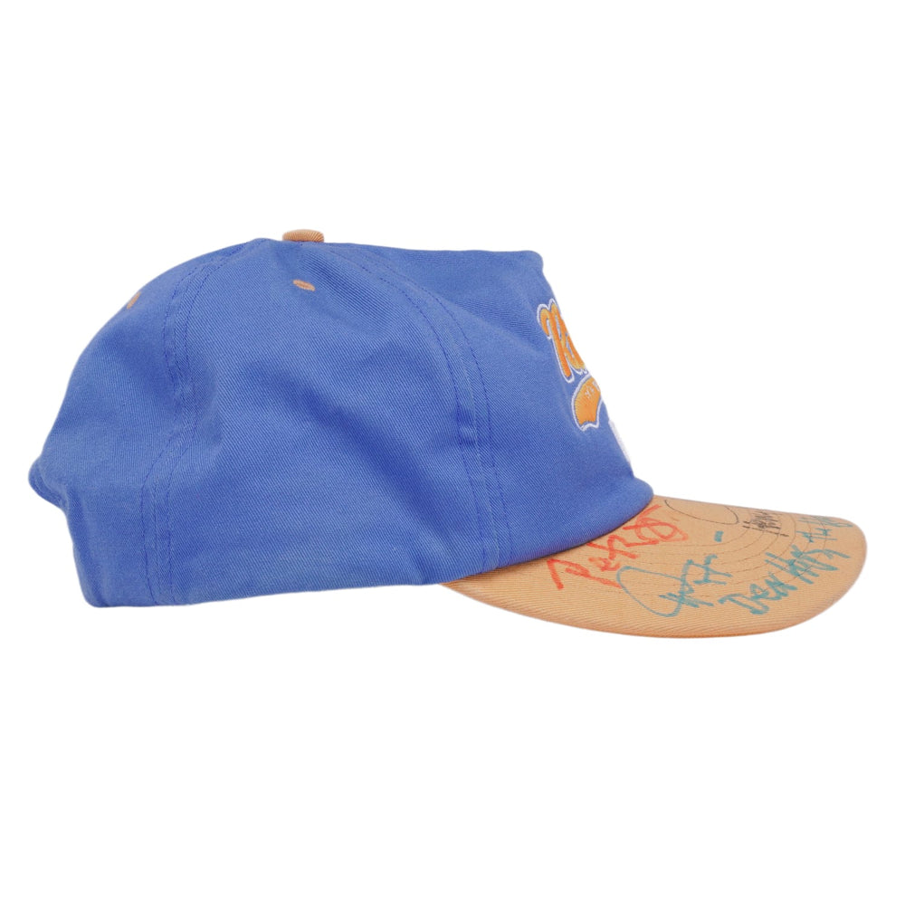 A left-side profile view of the cobalt blue Paly snapback hat, showcasing the structured six-panel crown, ventilation eyelets, and the clean contrast transition from the blue canvas panels to the cream-colored brim.